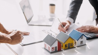 Mani di uomo con documenti e case in miniature